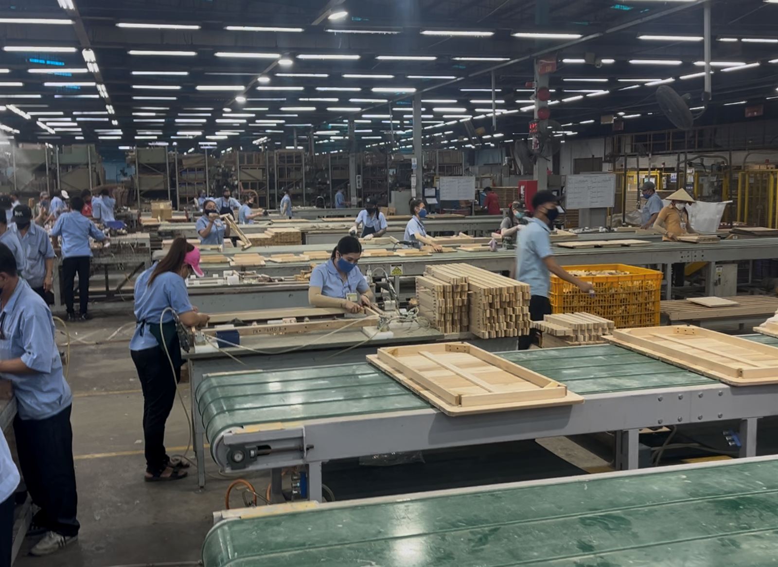 Workers assembling wooden frames along a production line