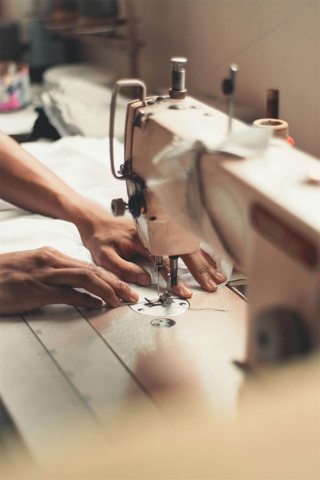 Hands guiding fabric through a sewing machine