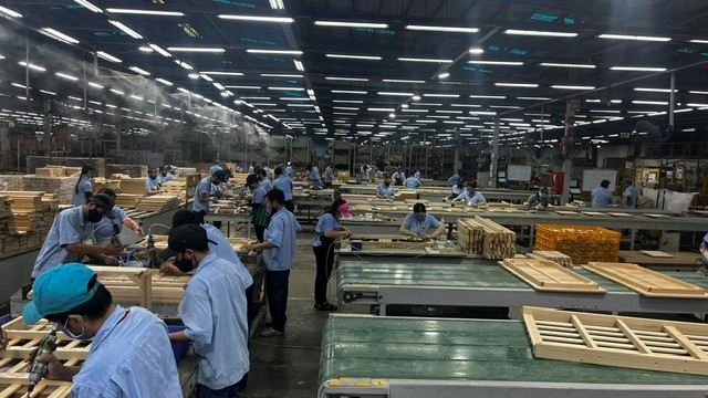 Workers assembling wooden furniture parts