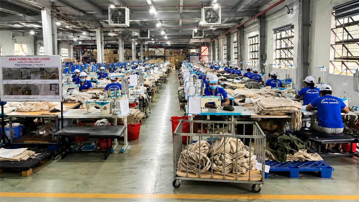 Garment workers at long rows of sewing stations